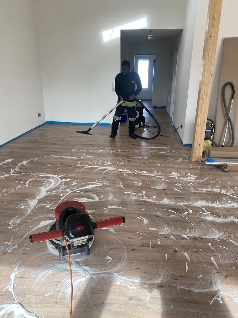 Bodenreinigung in einem Innenraum mit noch abgeklebten Wandrändern