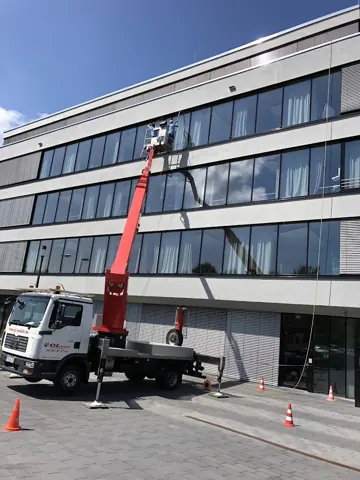 Arbeiten an einer Fassade mit Hebebühne