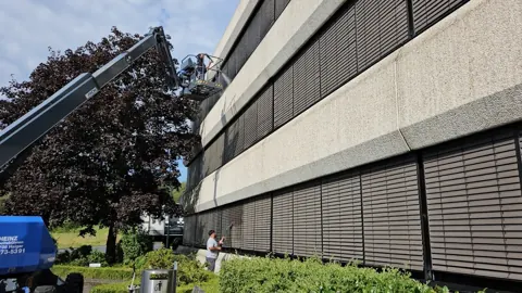 Reinigungsarbeiten an einer Fensterfassade mit Hebebühne
