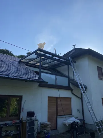 Reinigung eines gläsernen Vordachs am Wohnhaus