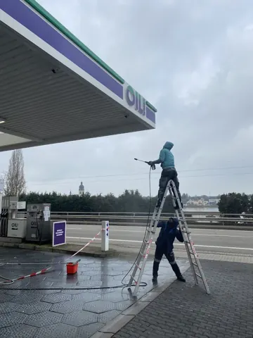 Reinigungsarbeiten an einer Tankstellenüberdachung