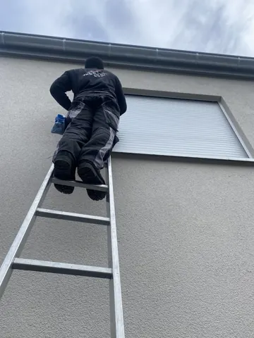 Reinigung am Fenster eines Wohnhauses