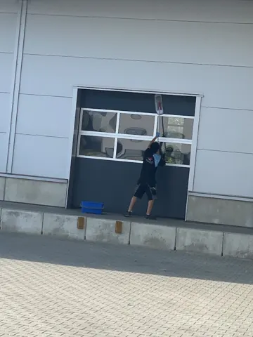 Reinigung eines verglasten Hallentors