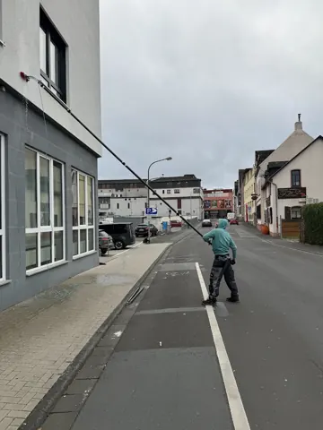 Reinigung einer Fensterfront mit Teleskopstange